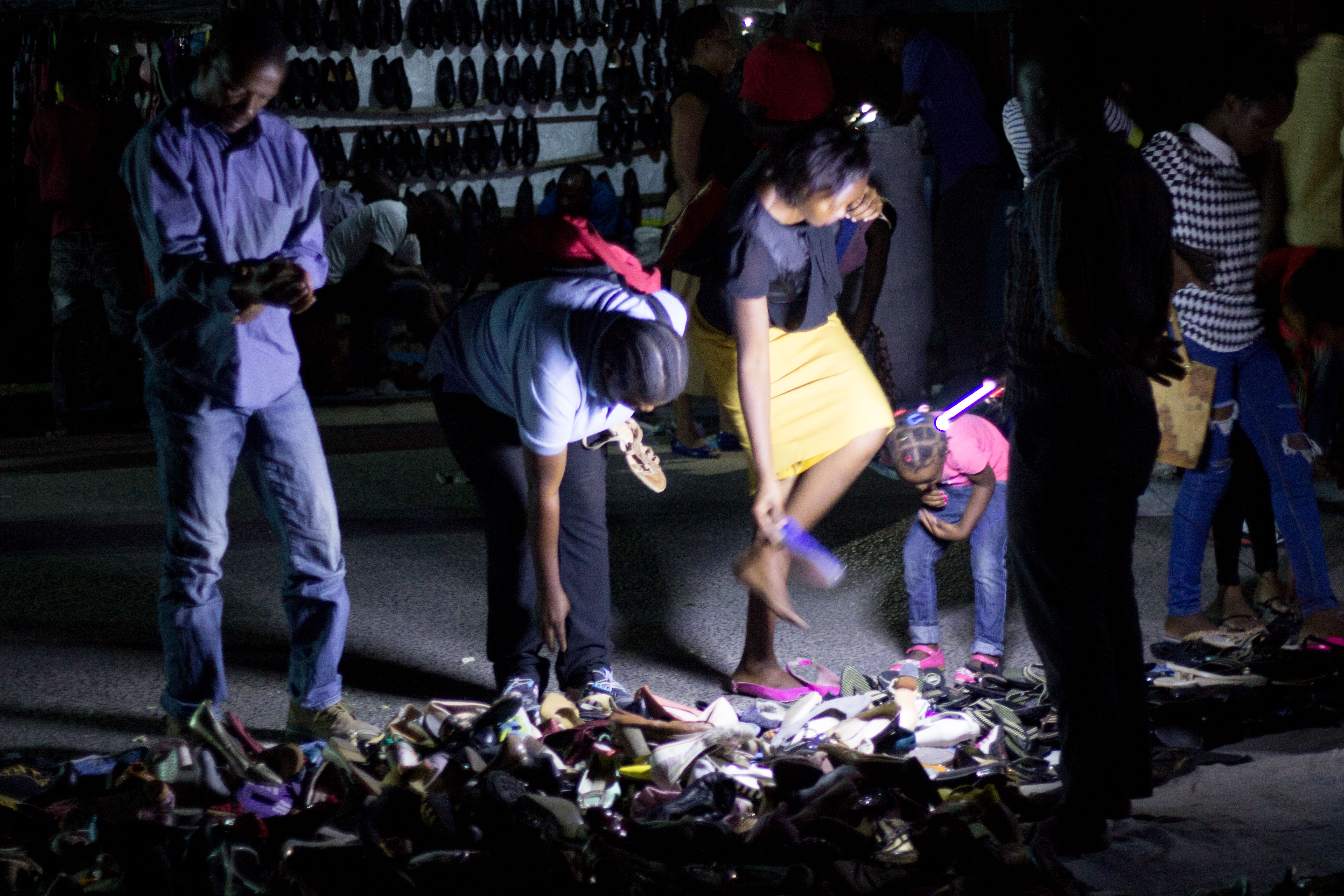 Night street market with vendors selling clothes and shoes